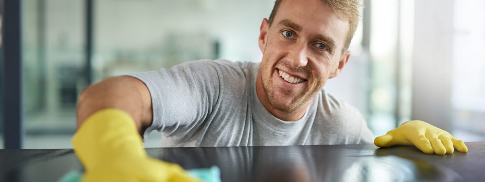 Portrait of a young man wiping off the surfaces in an office